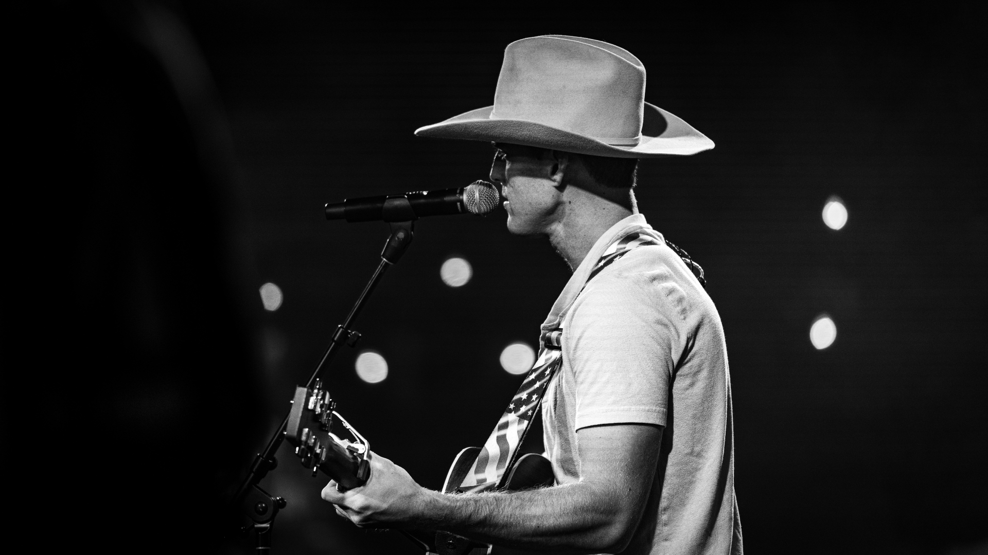 Black and white photograph of Michael Patrick Joyce singing in a cowboy hat